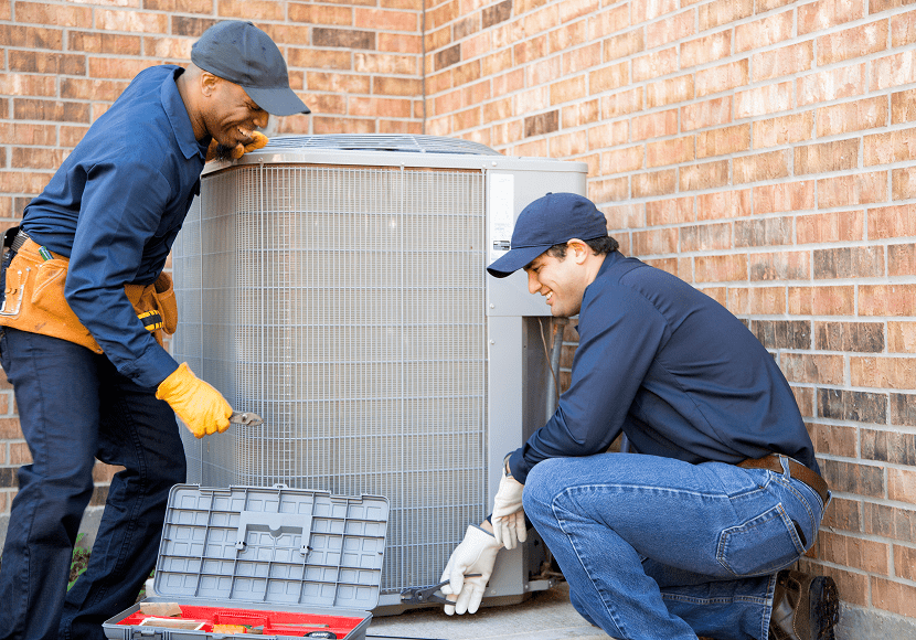 Technicians repairing outdoor air conditioning unit