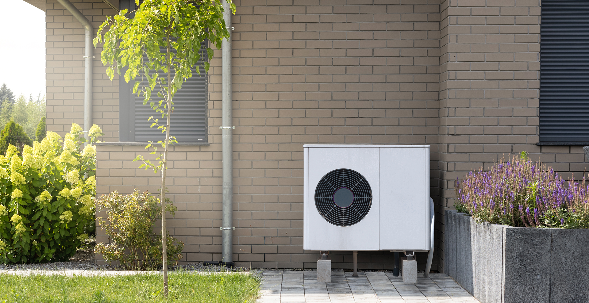 Outdoor heat pump unit by house wall